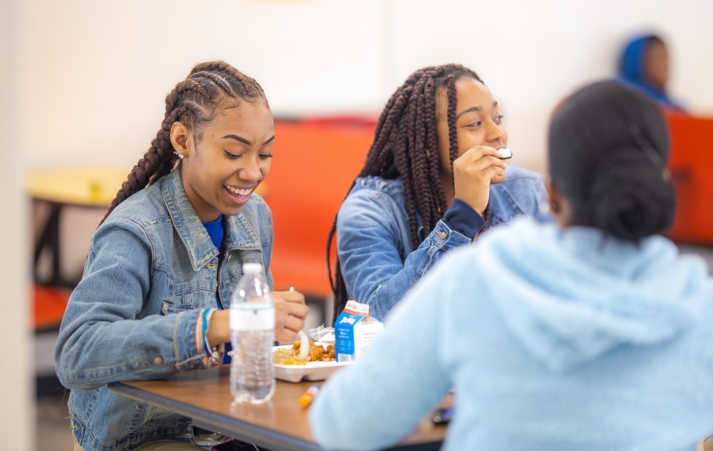Kids eating at a cafeteria table Kids eating at a cafeteria table